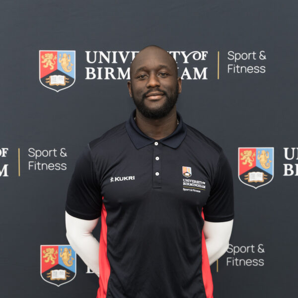 Man smiling in front of backdrop.