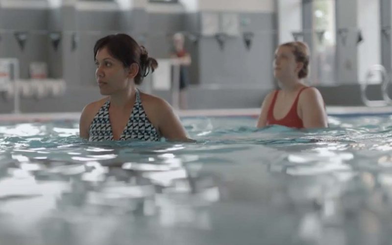Two women standing in the pool during an aqua class